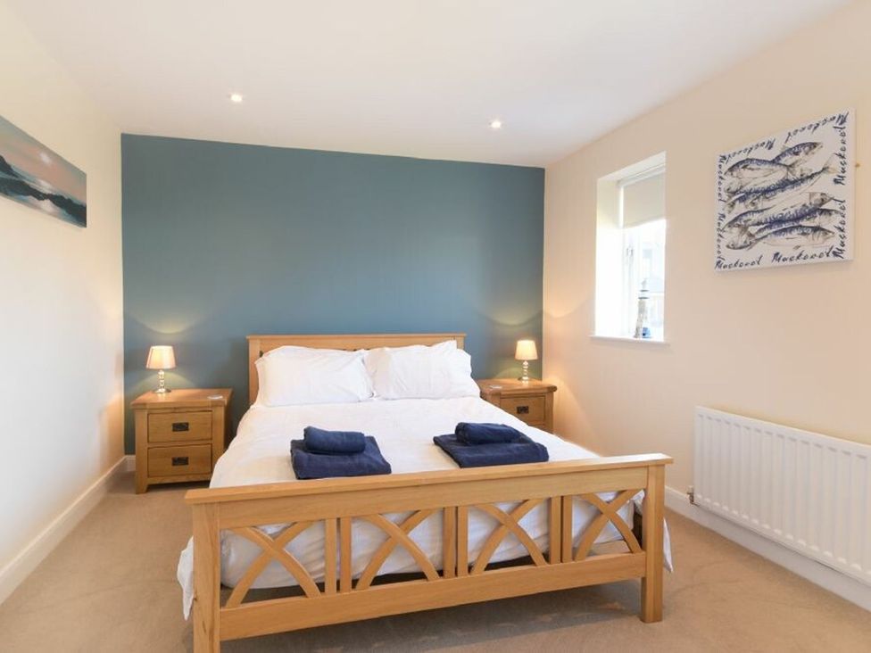 A bedroom with a bed and nightstand at Beach Walk in Chathill