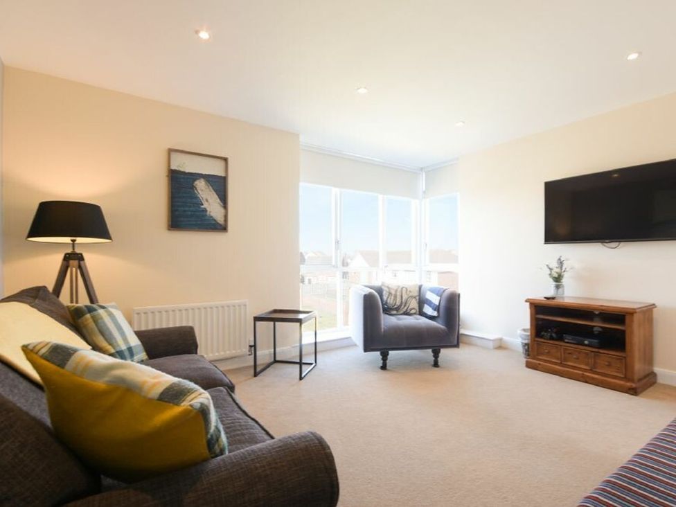 A living room with a sofa and television at Beach Walk in Chathill