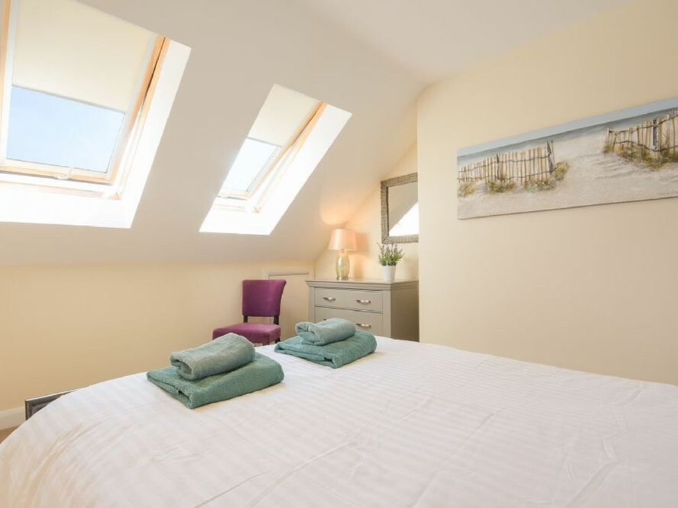 A bedroom with a bed and towels at Beach Walk in Chathill