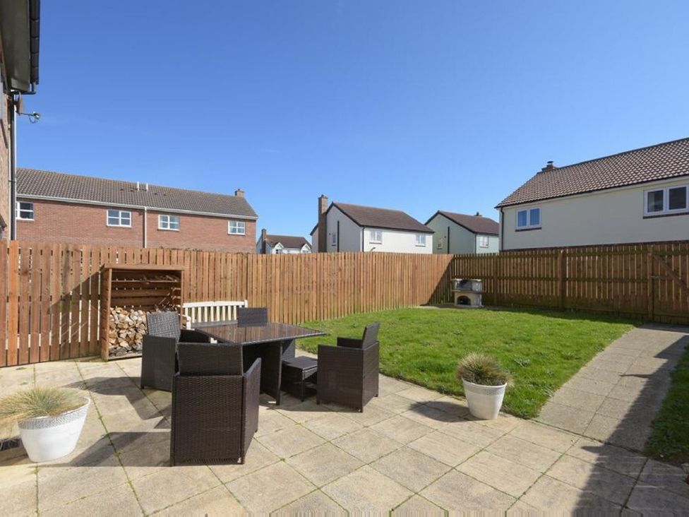A garden with a table and chairs at Beach Walk in Chathill