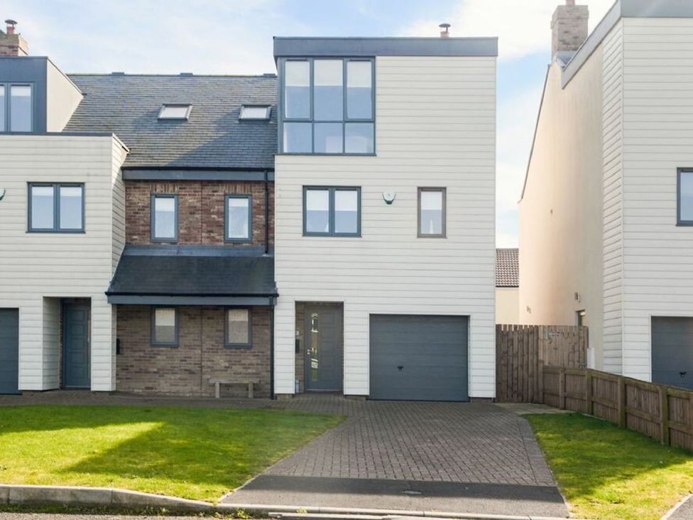 A house with a garage and front door at Beach Walk in Chathill