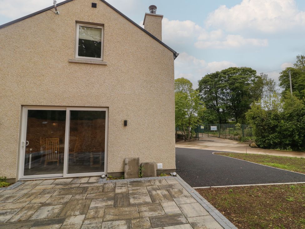 An exterior view of a house with a patio area at Brook Cottage, Coleraine