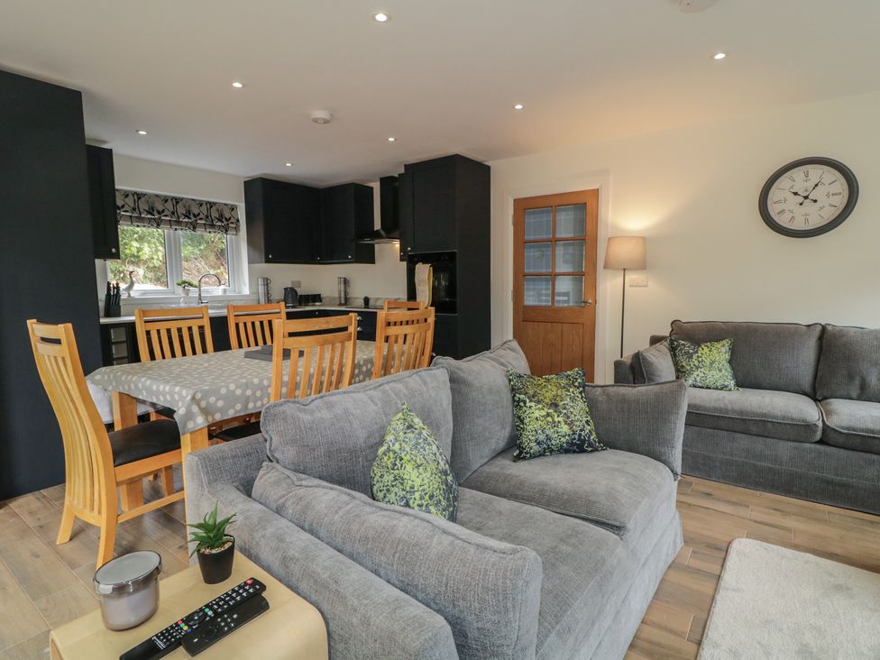 A living room with a dining table and sofa at Brook Cottage in Coleraine