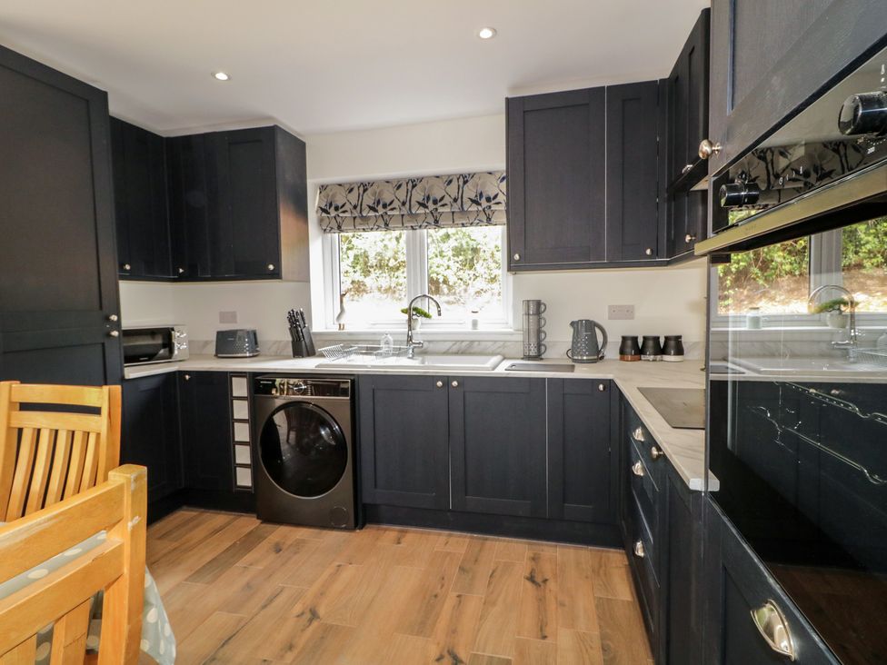 A kitchen with cabinets and appliances at Brook Cottage Coleraine