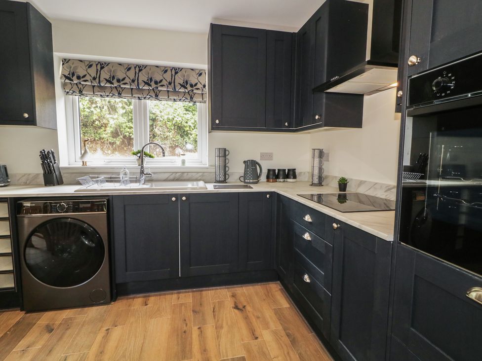 A kitchen with a sink and dishwasher at Brook Cottage in Coleraine