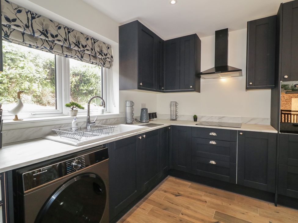 A kitchen with cabinets and a sink at Brook Cottage in Coleraine