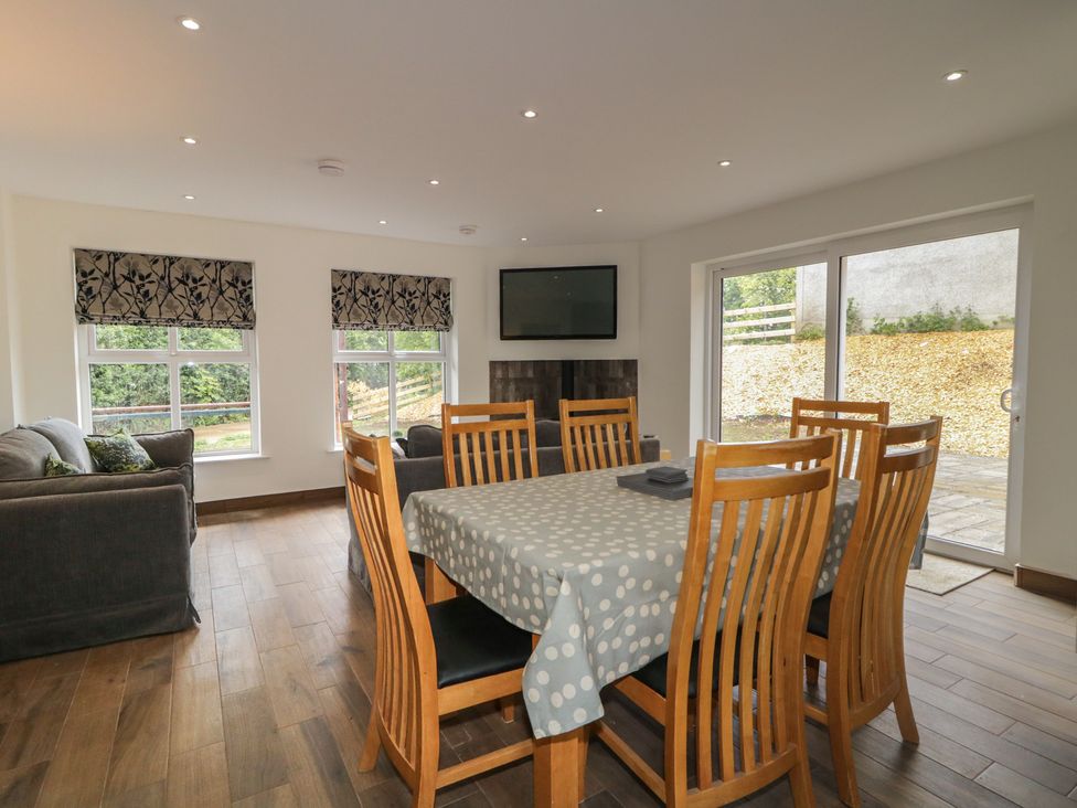 A dining room with a table and chairs at Brook Cottage in Coleraine