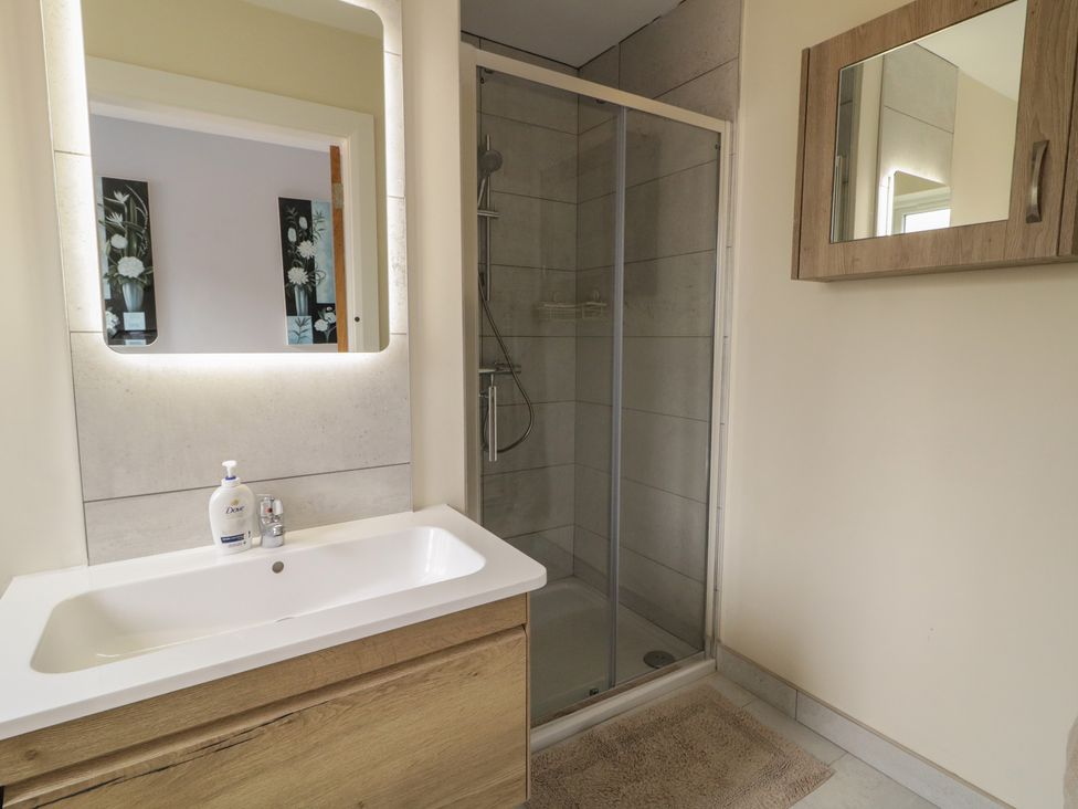A bathroom with a sink and a shower at Brook Cottage in Coleraine