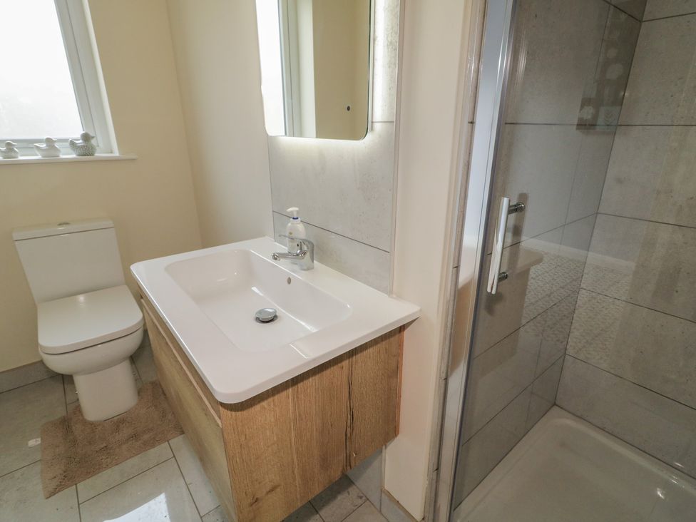 A bathroom with a sink and shower at Brook Cottage in Coleraine