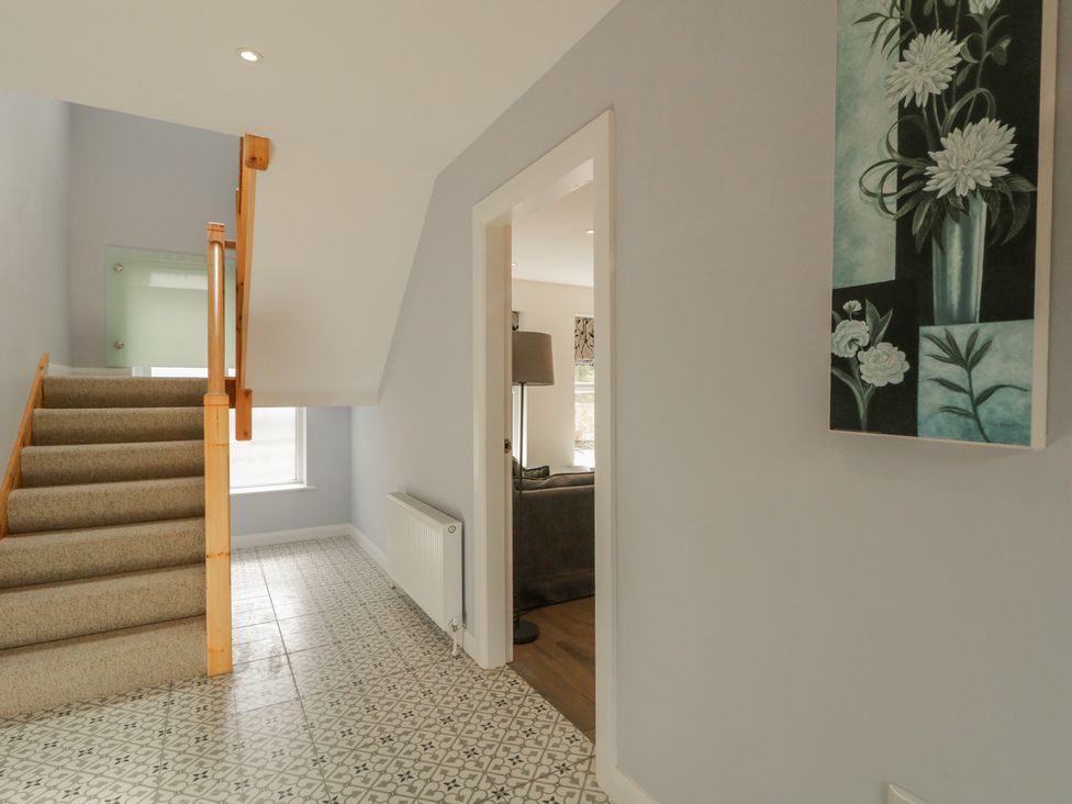 A hallway with stairs and wall artwork at Brook Cottage in Coleraine