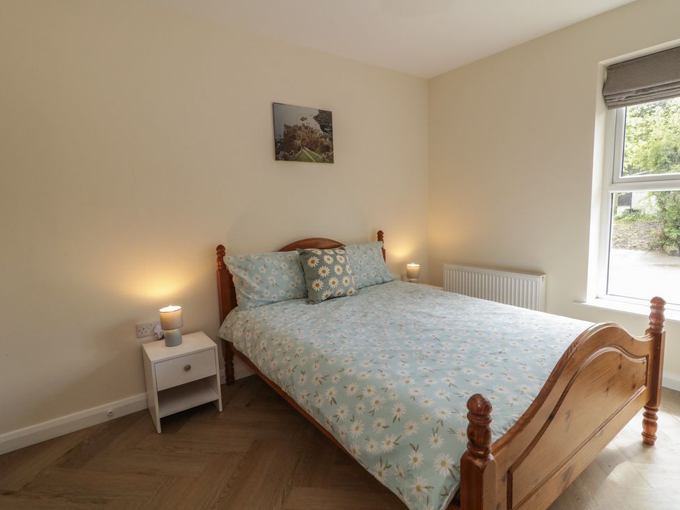 A bedroom with a bed and bedside table at Brook Cottage in Coleraine