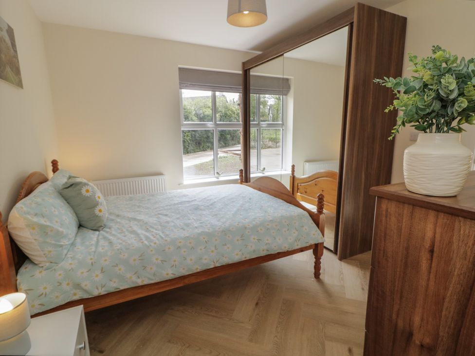 A bedroom with a bed and wardrobe at Brook Cottage in Coleraine
