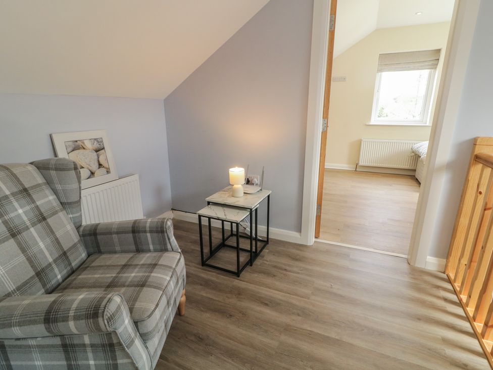 A landing with a chair and table at Brook Cottage in Coleraine