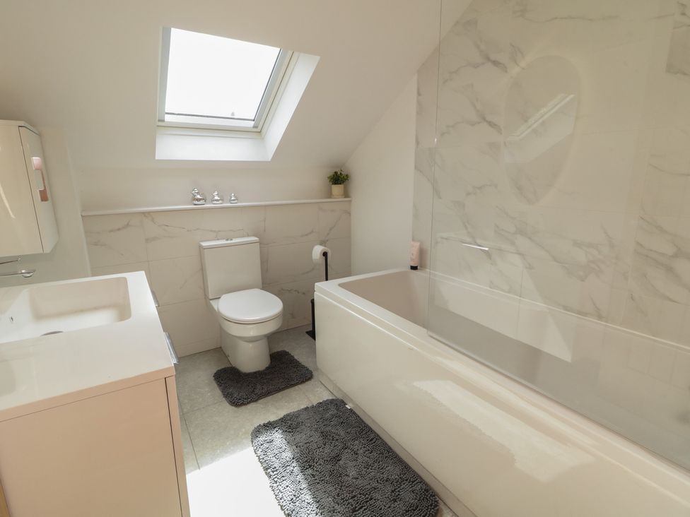 A bathroom with a bathtub, sink, and toilet at Brook Cottage in Coleraine