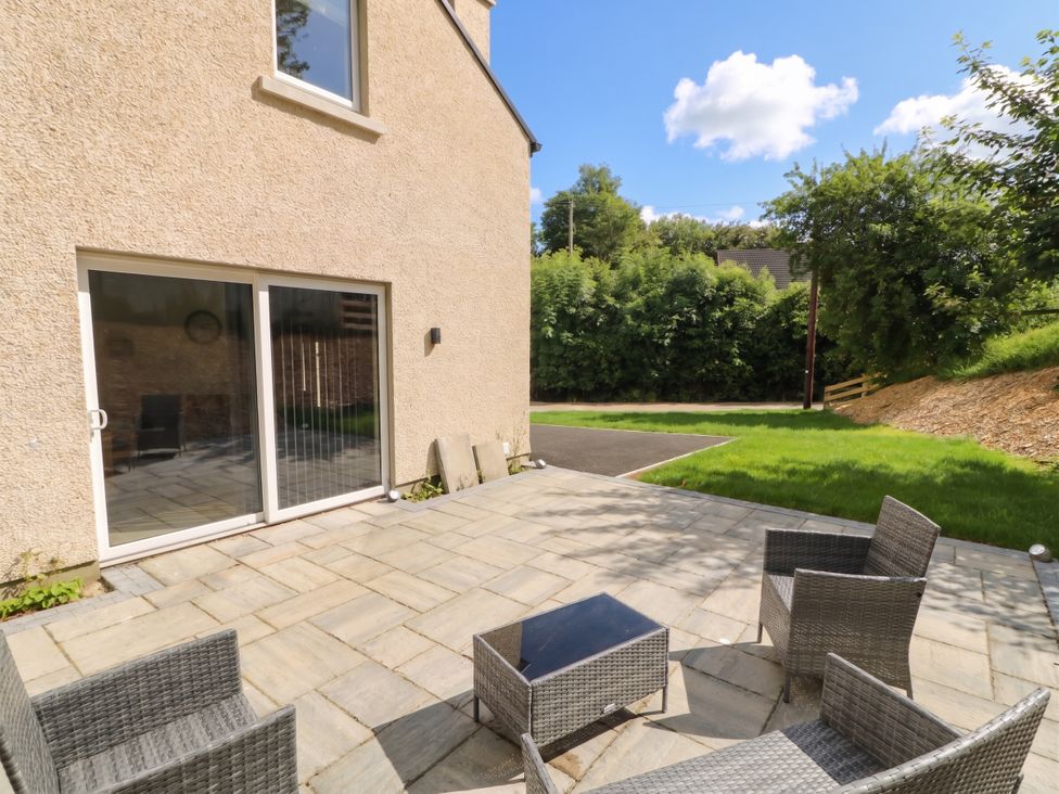 An outdoor patio area with chairs and a sliding door at Brook Cottage Moneydig near Coleraine
