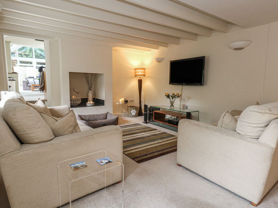 A living room with sofas and a television at Woodbine Cottage in Weymouth