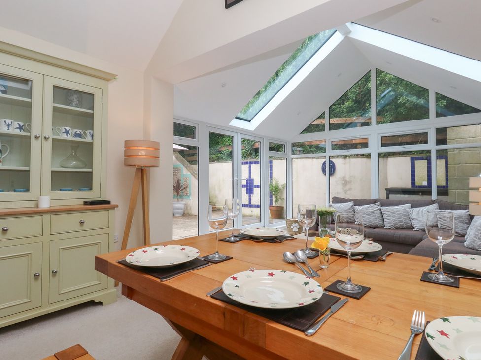 A dining area with a wooden table and chairs at Woodbine Cottage in Weymouth