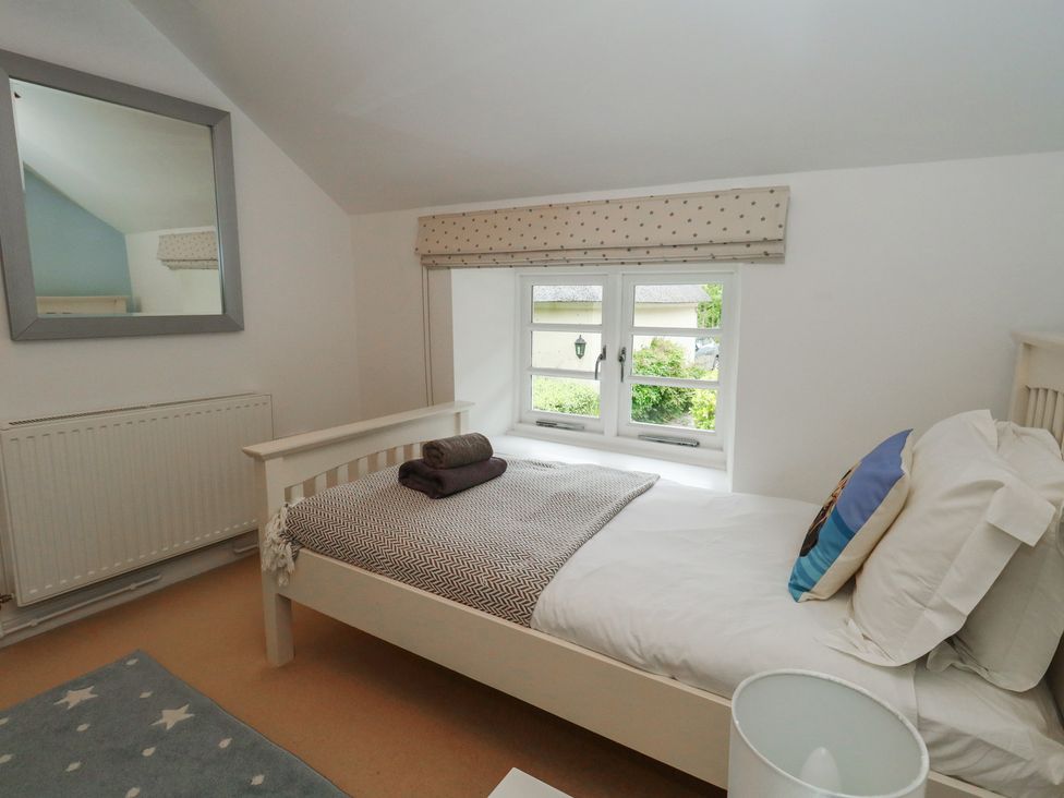A bedroom with a bed and a window at Woodbine Cottage in Weymouth