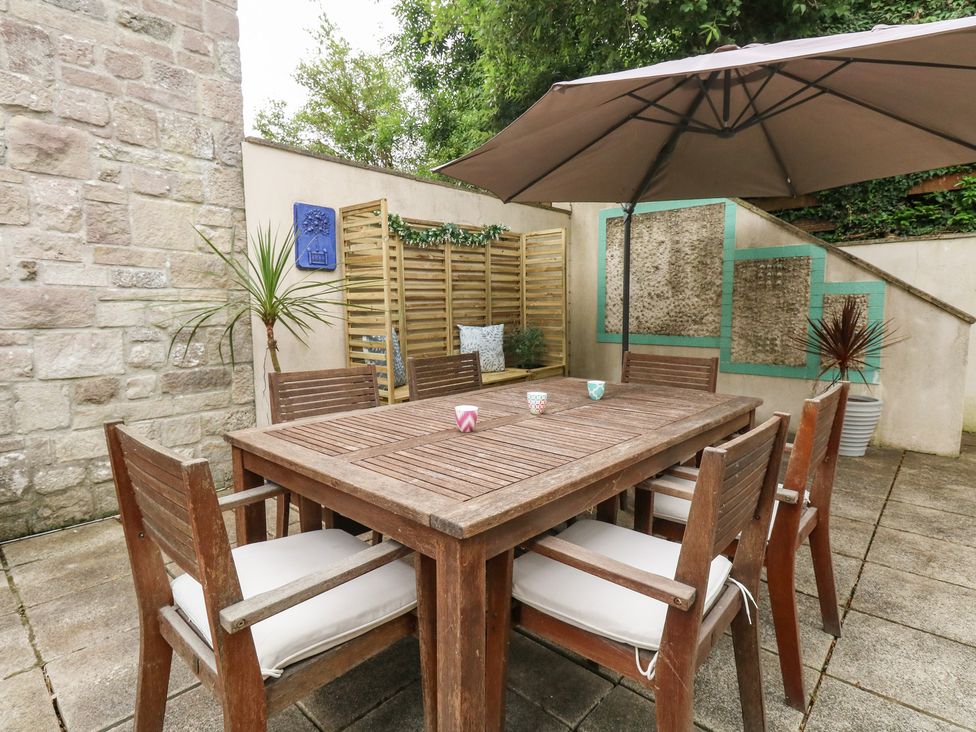 An outdoor dining area with a table and chairs at Woodbine Cottage in Weymouth