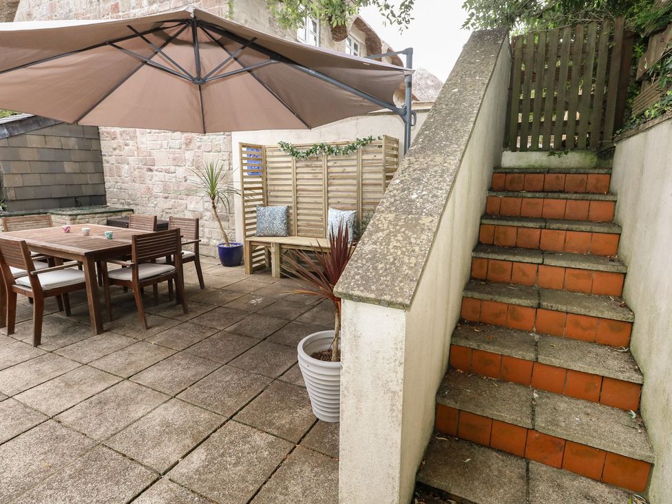 An outdoor area with a dining table and chairs at Woodbine Cottage in Weymouth