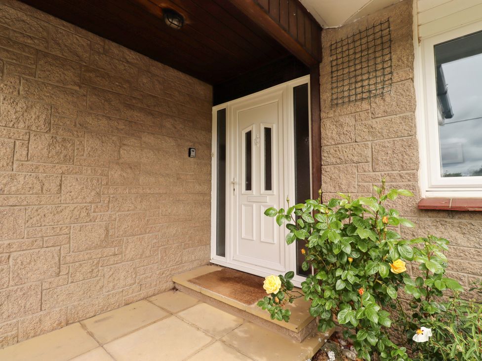 An entrance with a front door and a flowering plant at Campden in Rennington near Embleton