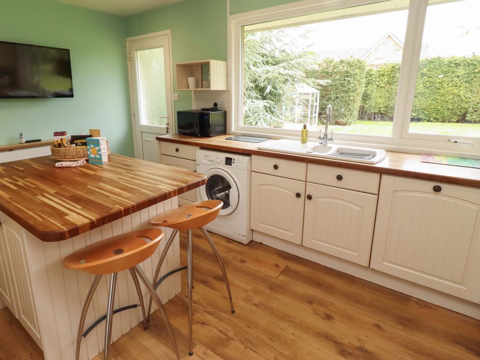 A kitchen with a washing machine and sink at Campden in Rennington near Embleton