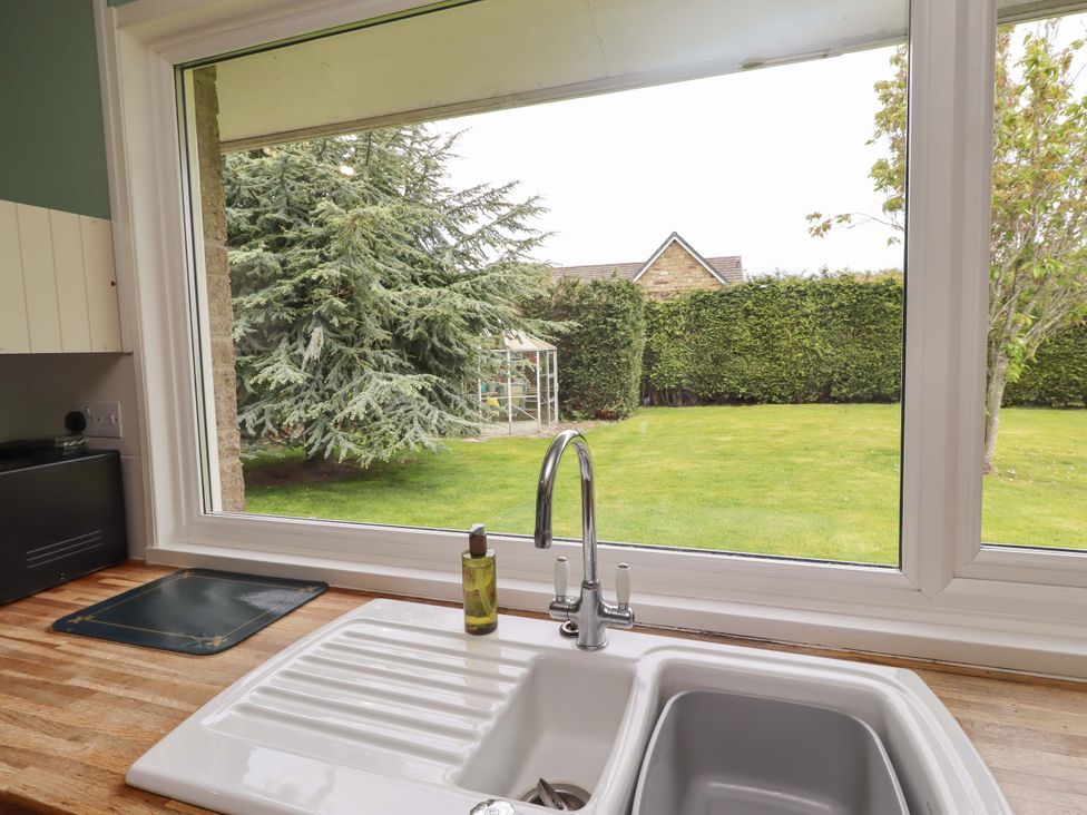 A kitchen with a sink and view of a garden at Campden Rennington near Embleton