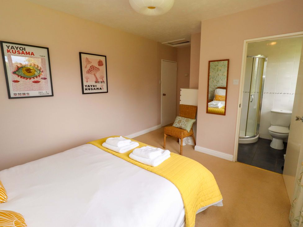 A bedroom with a bed and attached bathroom at Campden in Rennington near Embleton