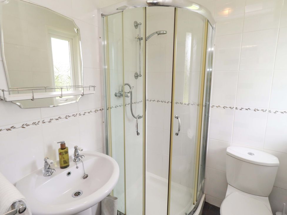 A bathroom with a shower, sink, and toilet at Campden in Rennington near Embleton