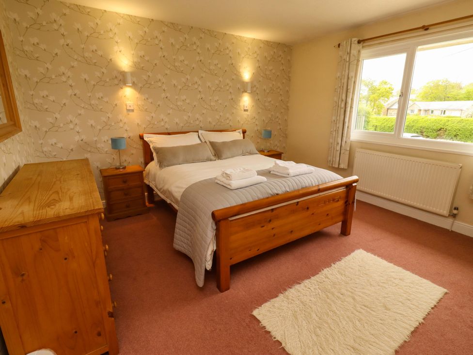 A bedroom with a bed and dresser at Campden in Rennington near Embleton