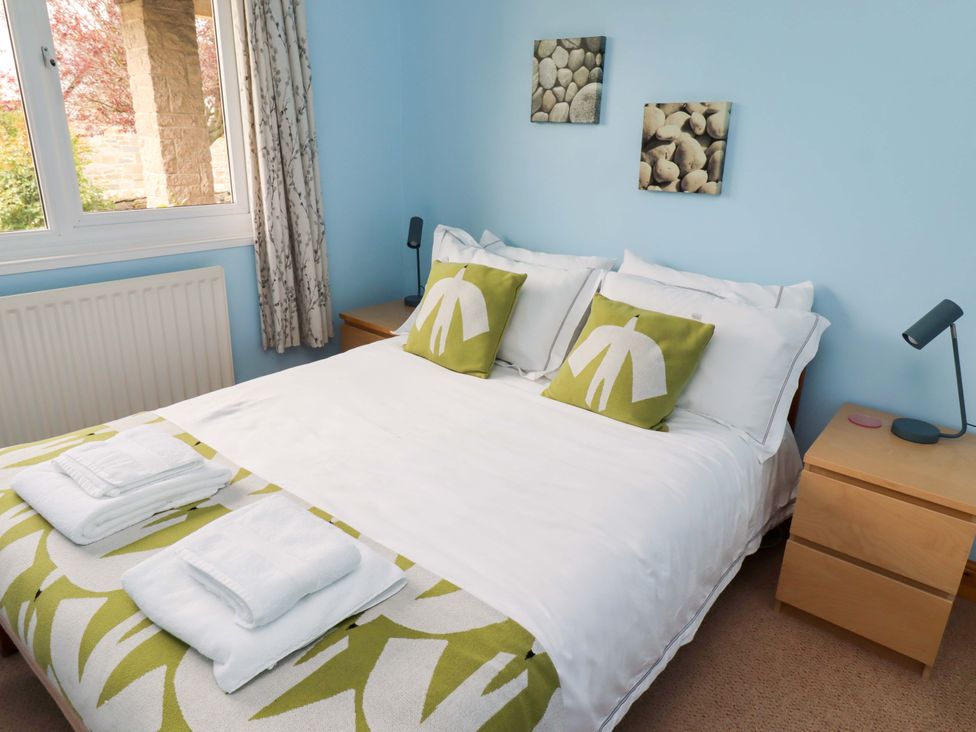 A bedroom with a bed and bedside table at Campden in Rennington near Embleton