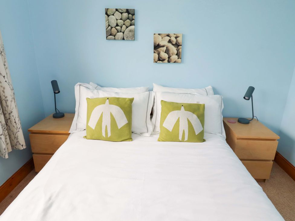 A bedroom with a bed and bedside tables at Campden in Rennington near Embleton
