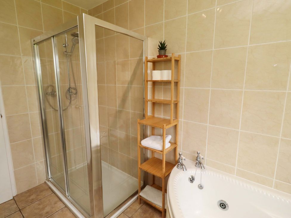 A bathroom with a shower and bathtub at Campden in Rennington near Embleton