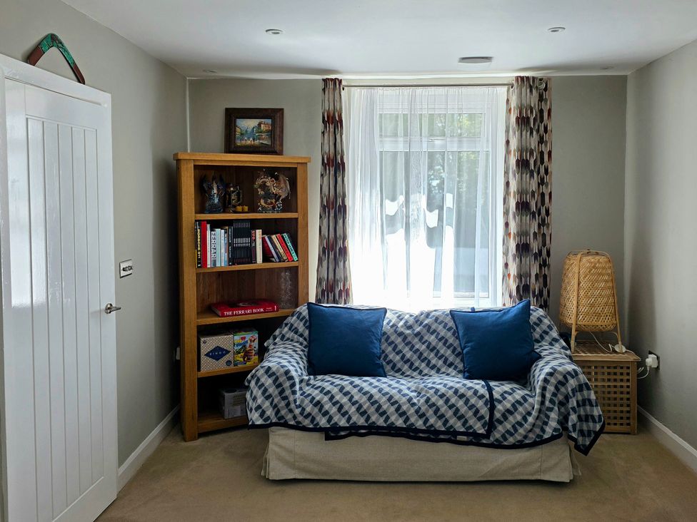 A living room with a sofa and bookshelf at Pant in Holyhead