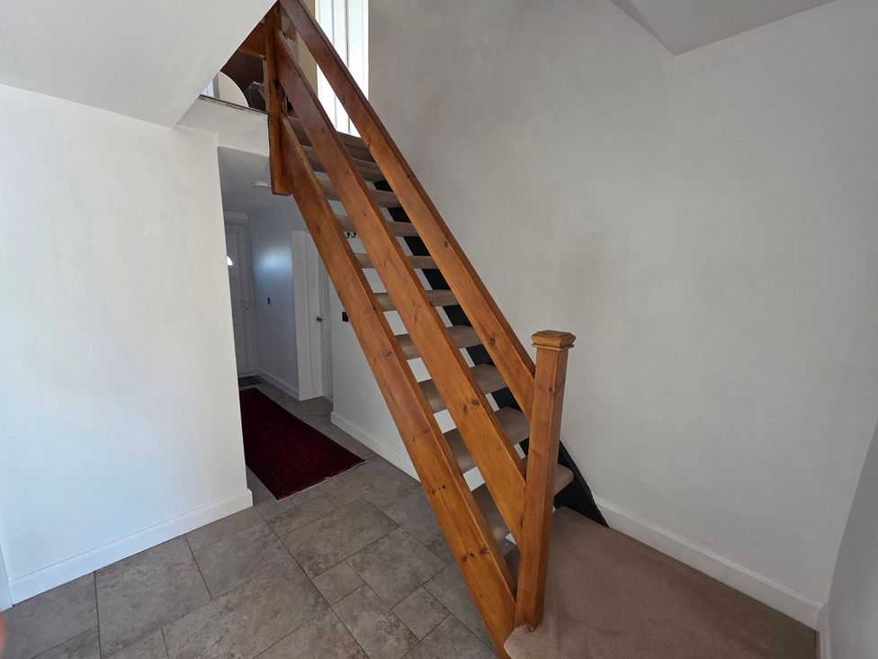 A staircase and door in a hallway at Pant in Holyhead