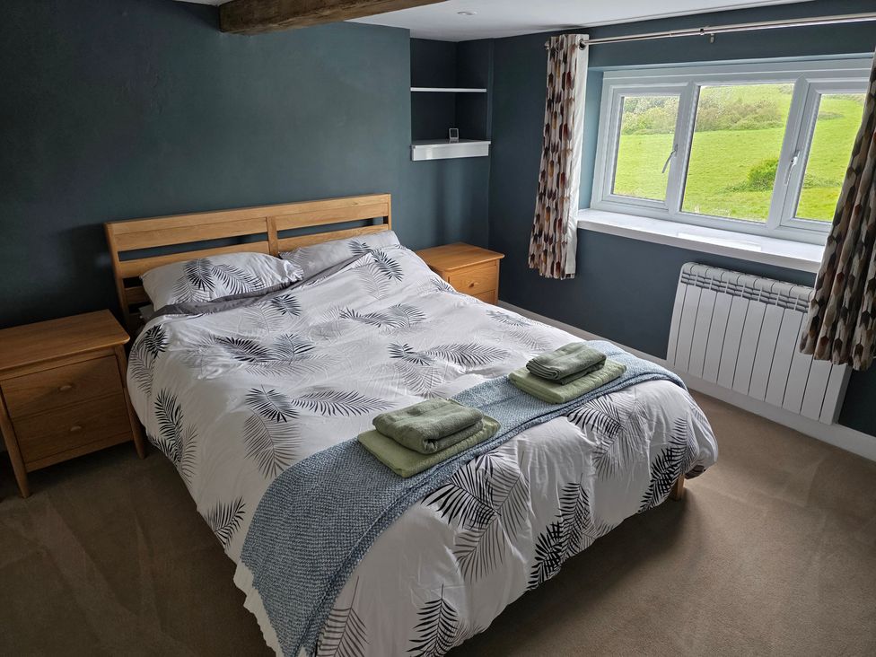 A bedroom with a bed and nightstands at Pant in Holyhead