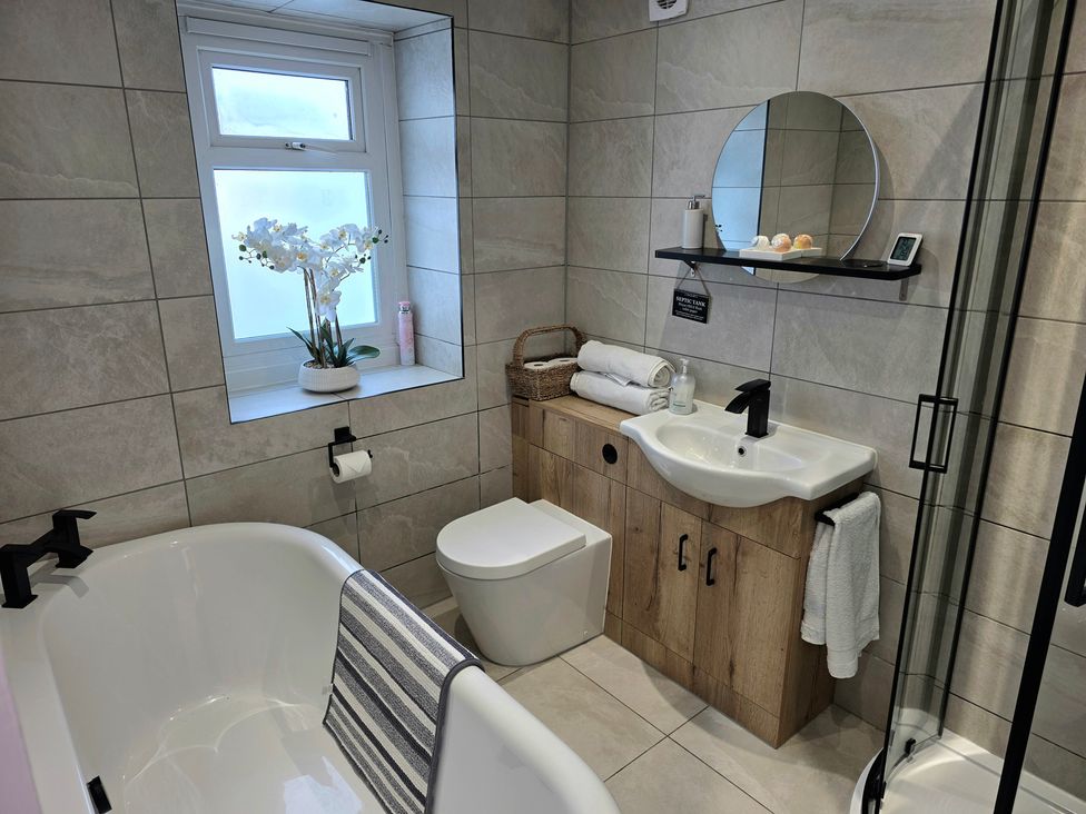 A bathroom with a bathtub, sink, and toilet at Pant in Holyhead