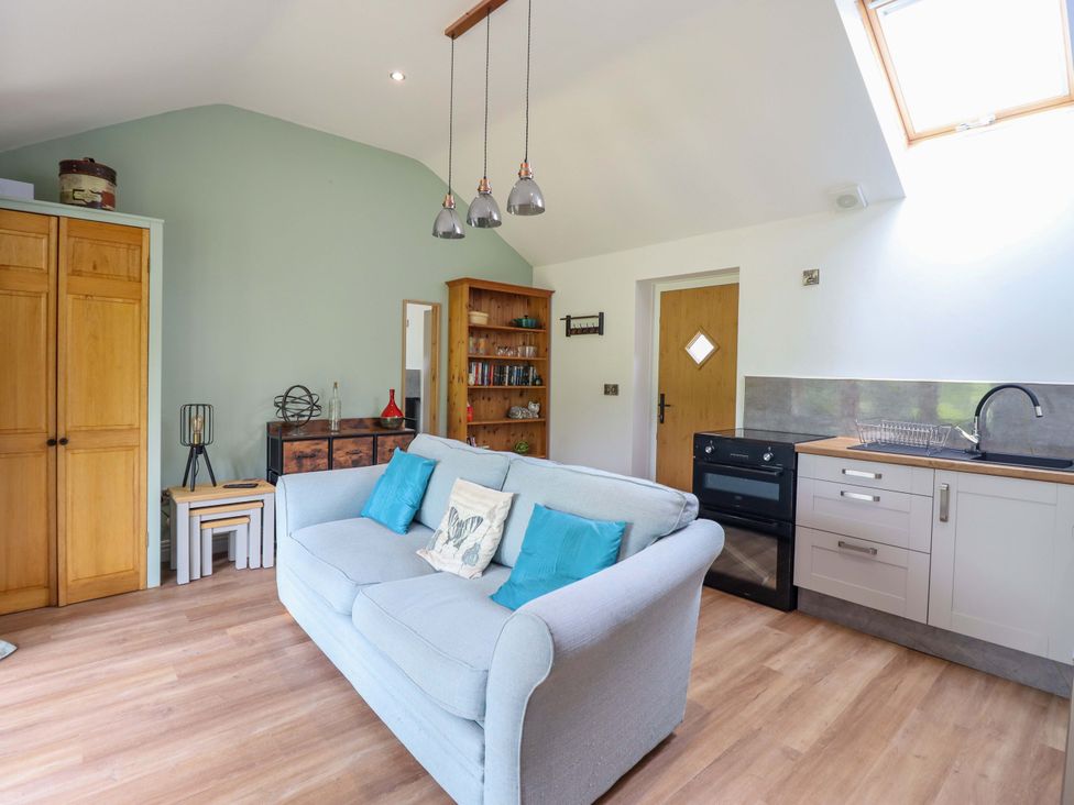 A living room with a sofa and kitchen cabinet at Henlle Home Farm in Gobowen