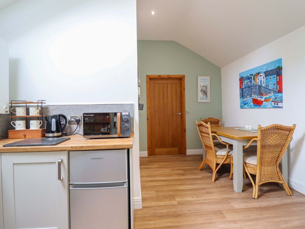 A kitchen with appliances and a dining area at Henlle Home Farm in Gobowen