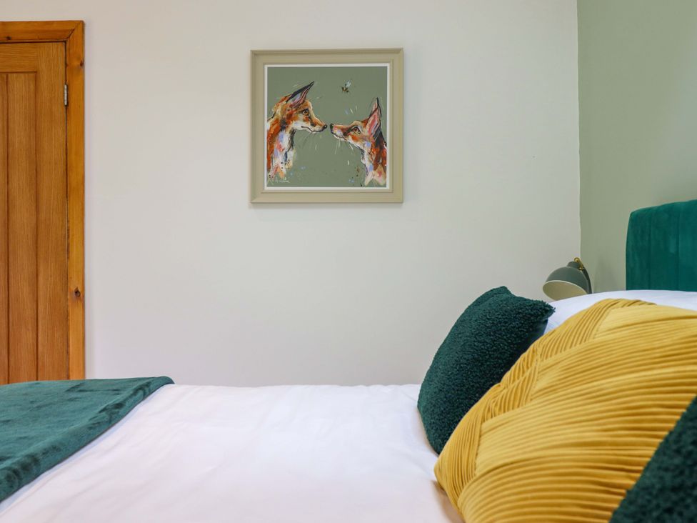 A bedroom with a bed, pillows, and a painting at Henlle Home Farm in Gobowen