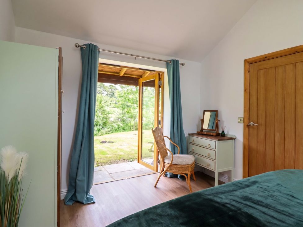 A bedroom with a chair and a table at Henlle Home Farm Gobowen