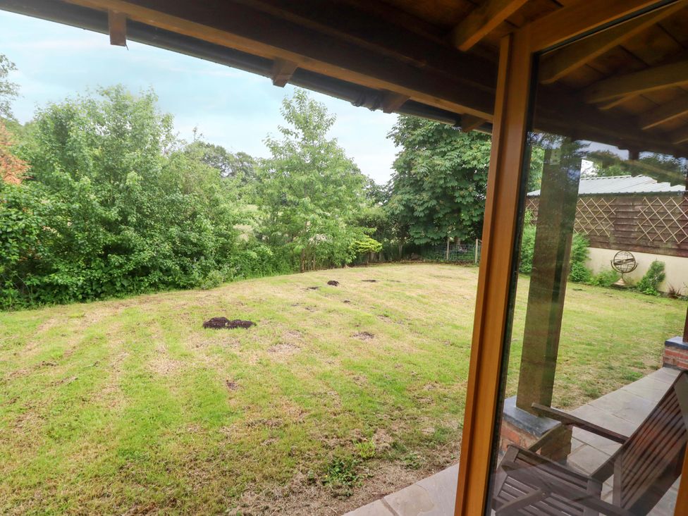 A garden with grass and trees at Henlle Home Farm Gobowen