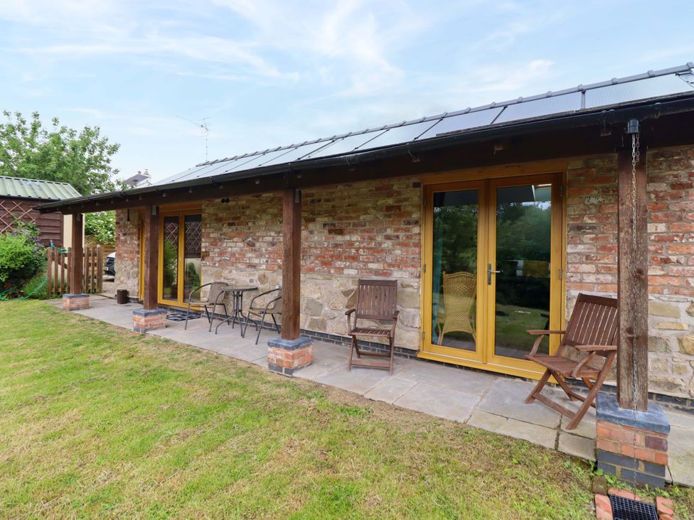 A patio area with chairs and a table at Henlle Home Farm in Gobowen
