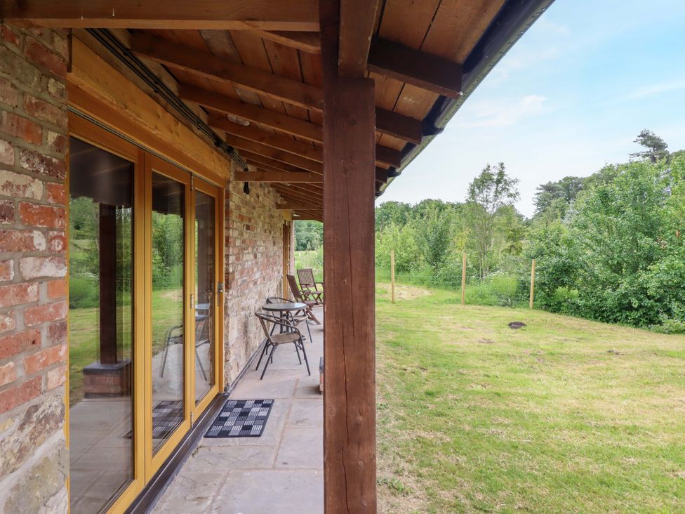 An outdoor area with chairs and a table at Henlle Home Farm in Gobowen