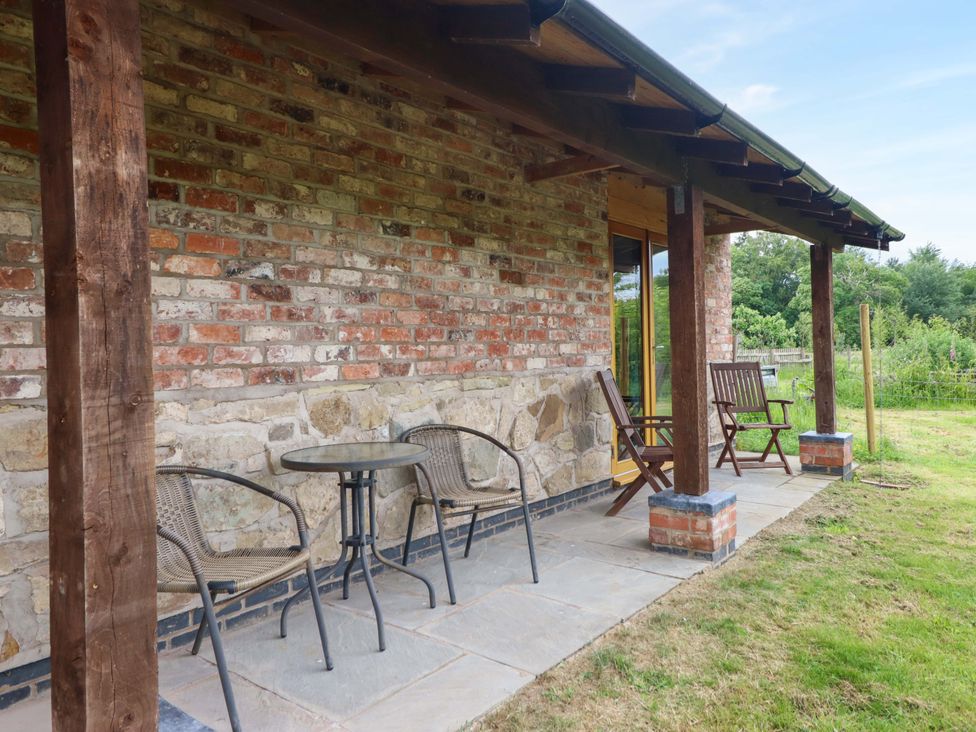 A patio area with a table and chairs at Henlle Home Farm in Gobowen