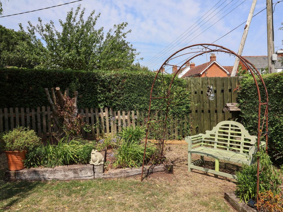 A garden with a bench and archway at Pete's Place Taunton