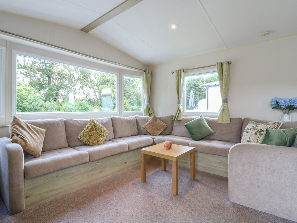 A living room with a sofa and table at Forest Retreat - FO26 Saxmundham