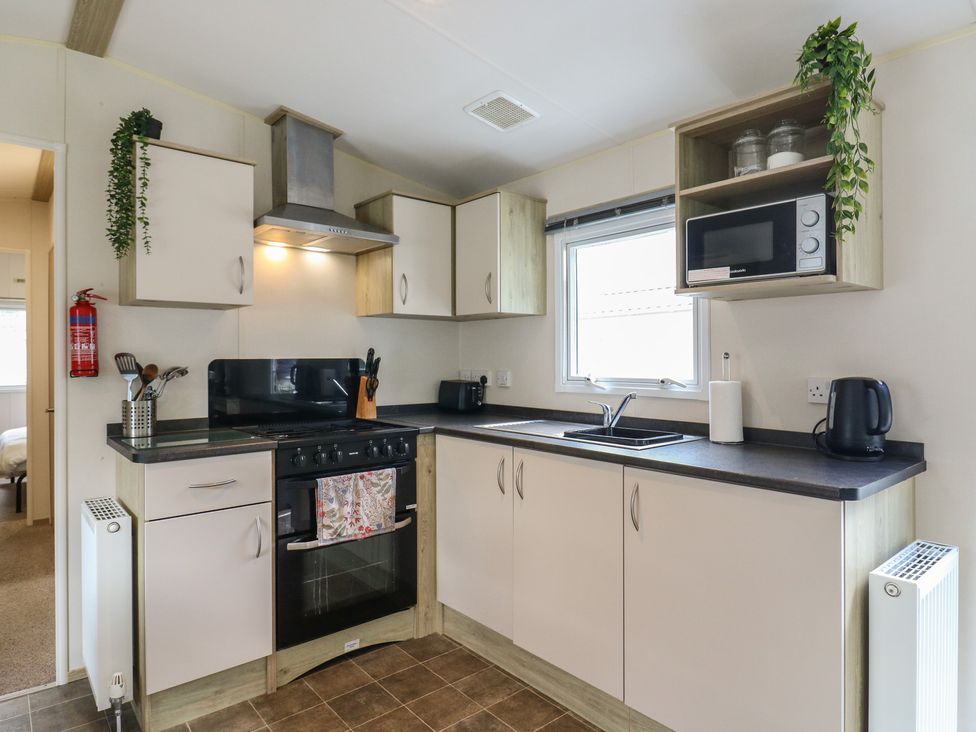 A kitchen with a cooker and sink at Forest Retreat - FO26 in Saxmundham