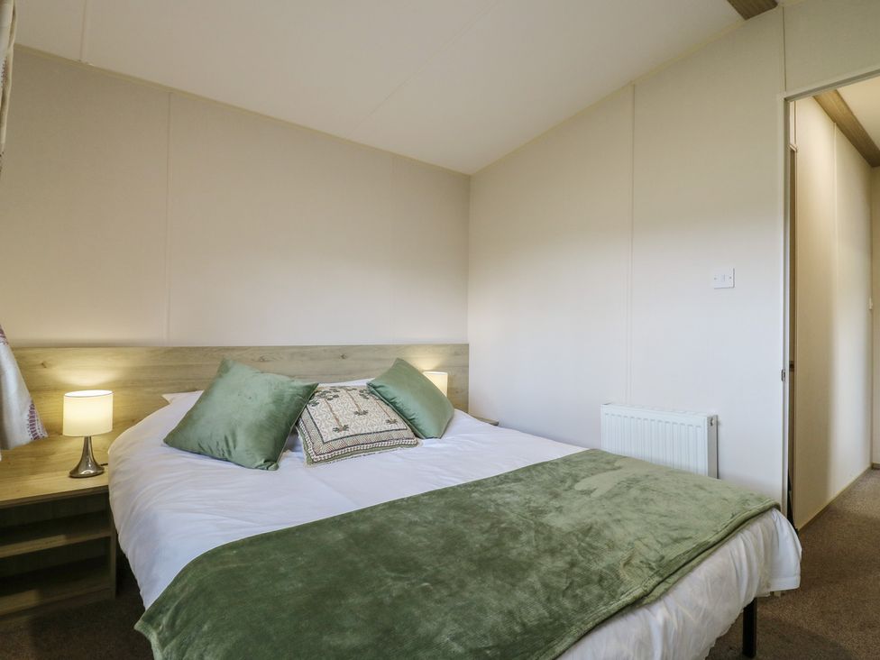 A bedroom with a bed and bedside lamps at Forest Retreat - FO26 in Saxmundham