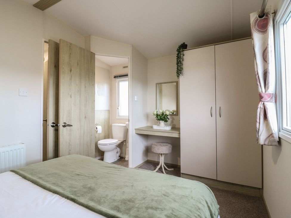 A bedroom with a bed and a wardrobe at Forest Retreat - FO26 Saxmundham